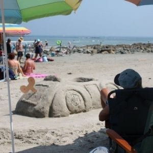 People On Wells Beach With Sand Sculpture